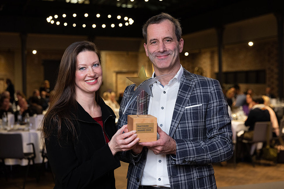 Zwei Personen mit dem Real Estate Social Impact Investing Award 2024